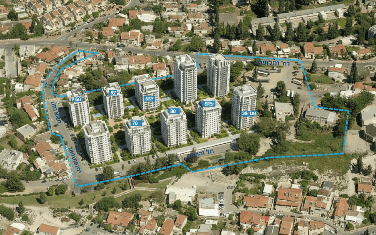 תמונת נושא של המאמר על פינוי בינוי בית שמש המציגה צילום אוויר של שכונת מגורים המציג מתחם של עשרה בנייני מגורים מודרניים ולבנים המוקפים בקו מתאר מקווקו בצבע תכלת, כאשר על גגות הבניינים מופיעים מספרי זיהוי בולטים ושמות רחובות מסומנים בעברית על הכבישים הסמוכים ("רח' וולפסון", "רח' מצדה"), מה שממחיש תכנון עירוני או מפה של פרויקט נדל"ן ספציפי.